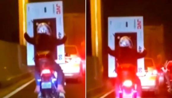 Dos personas llevaban un gran televisor en una moto, en plena hora punta.