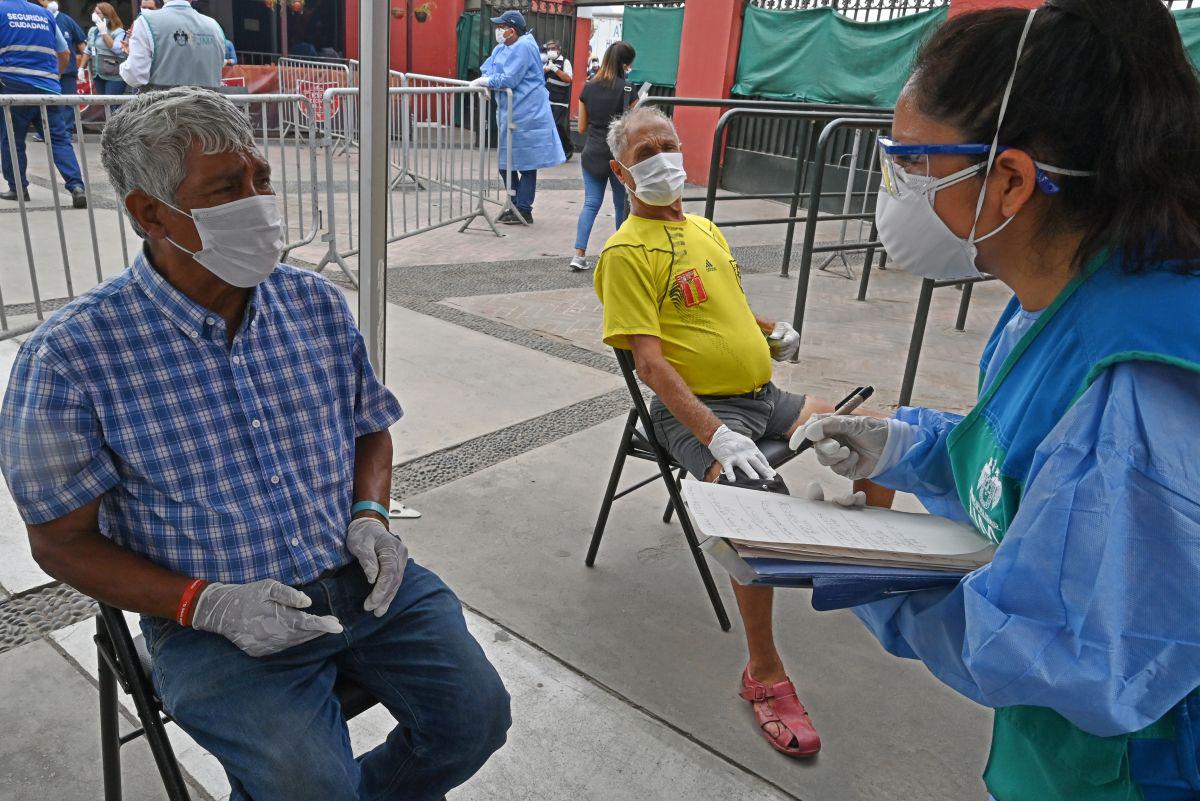 Personas sin hogar son entrevistadas por el personal de salud a su llegada a un refugio establecido en la plaza de toros bicentenario de Acho en Lima durante la cuarentena a causa del nuevo coronavirus, COVID-19 (Foto: Cris Bouroncle / AFP)