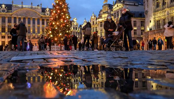 Varias personas disfrutan de la iluminación navideña instalada en la Gran Place de Bruselas. (EFE/ Olivier Hoslet).