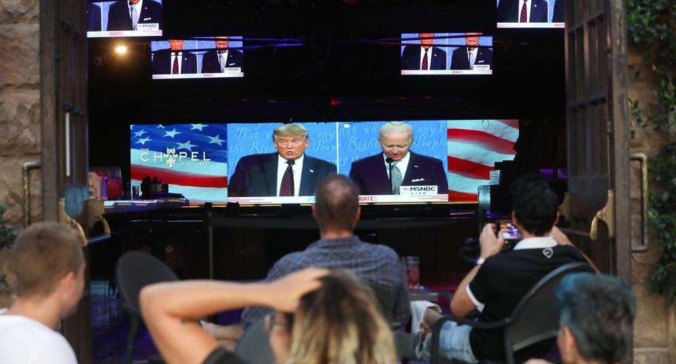 La gente se sienta y mira una transmisión del primer debate entre Donald Trump y  Joe Biden, en West Hollywood, California. Foto del 29 de setiembre de 2020. (Mario Tama/Getty Images/AFP).