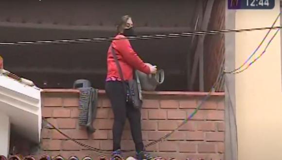 La vecina Sara Salas coge un balón de gas para evitar un desalojo en su casa ubicada en la urbanización La Modesta, en Surco. (Captura. Canal N)