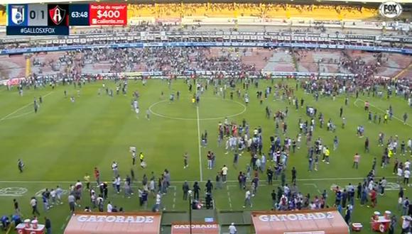 Los hinchas de Querétaro y Atlas invadieron el terrero de juego. Foto: Captura de pantalla de Fox Sports.