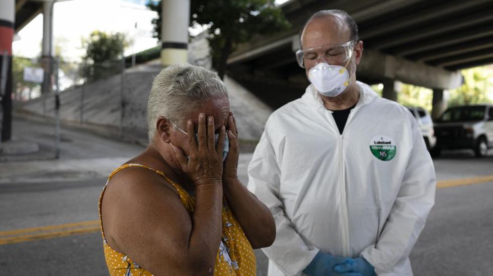 Marta Gonzalez (L), a homeless woman, reacts after a talk with Ronald Book (R), chairman at Miami-Dade County Homeless Trust,  before being tested for coronavirus disease (COVID-19) in Downtown Miami on April 16, 2020. - The government reported Thursday that another 5.2 million US workers filed for unemployment benefits, taking the four-week total to 22 million, a staggering figure in a downturn that economists say presents the country with its most severe outlook since the Great Depression of the 1930s. (Photo by Eva Marie UZCATEGUI / AFP)