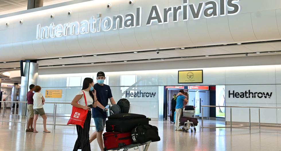 Pasajeros que usan PPE (equipo de protección personal), incluida una máscara facial como medida de precaución contra COVID-19, caminan por la sala de llegadas después de aterrizar en la Terminal Dos del Aeropuerto Heathrow de Londres. (Foto: AFP)