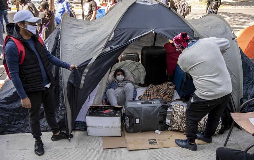 Stranded Peruvian citizens camp outside Peru's consulate in Santiago on April 30, 2020, as they wait for a solution after the borders between the countries were closed due to the new coronavirus pandemic, (Photo by Martin BERNETTI / AFP)