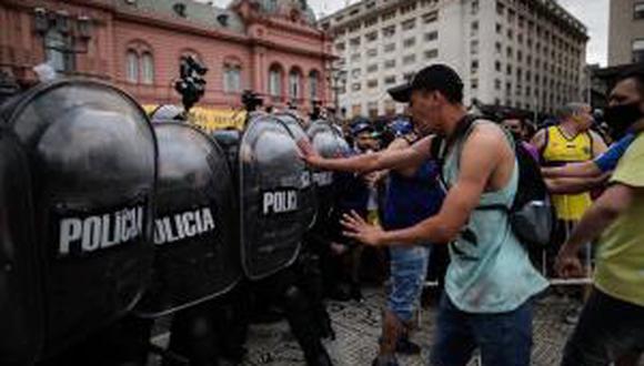 Un grupo de personas choca con la policía durante la espera para poder ingresar al velatorio de Diego Armando Maradona, hoy jueves en la Plaza de Mayo de Buenos Aires. (EFE/Juan Ignacio Ronconori).