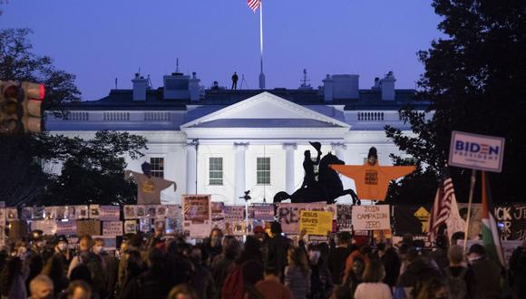 La Casa Blanca se ve al anochecer mientras la multitud se reúne en Black Lives Matter Plaza en Washington, DC, EE.UU. (EFE/MICHAEL REYNOLDS).