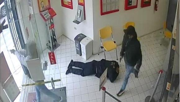 Uno de los delincuentes encapuchados en pleno asalto a la agencia bancaria que fue captado por las cámaras del recinto. (Captura de video)