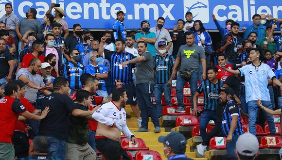 Aficionados del Querétaro y aficionados del Atlas originaron un conato de pelea que terminó invadiendo la cancha. (Foto: EFE)