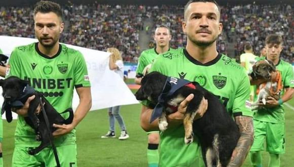 La campaña se llama “Llena el vacío en tu vida” y los jugadores del Dinamo de Bucarest salieron al campo cargando perros que buscan un hogar que los adopte. (Twitter)