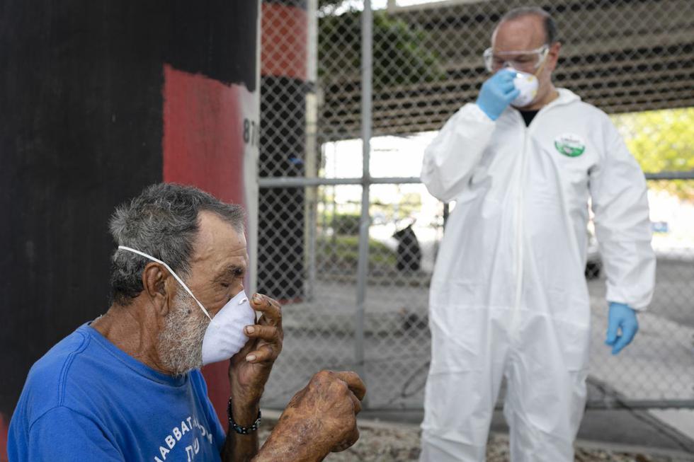 Emilio Brito, un hombre sin hogar, ajusta una máscara protectora luego de que un trabajador de Miami-Dade County Homeless Trust en el centro de Miami, le realizó una prueba de detección de la enfermedad por coronavirus (COVID-19)(Foto: Eva Marie Uzcategui / AFP)