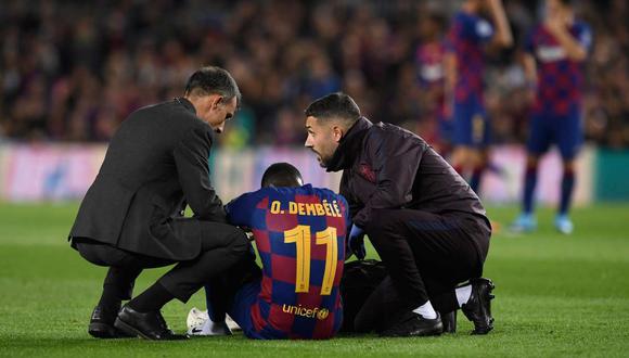 Barcelona's French forward Ousmane Dembele sits on the ground after an injury during the UEFA Champions League Group F football match between FC Barcelona and Borussia Dortmund at the Camp Nou stadium in Barcelona, on November 27, 2019. / AFP / Josep LAGO
