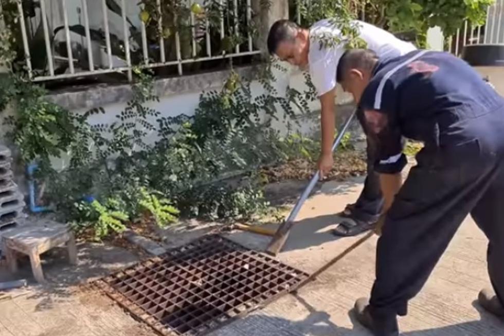 Con la ayuda de un rescatista abrió la alcantarilla de la calle. | Foto: YouTube/Newsflare