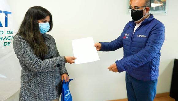 El jefe del SAT de Lima, Miguel Roa, entregó el dinero a la mujer que había extraviado 1300 soles en la sede principal de la entidad. (Foto: Servicio de Administración de Lima)