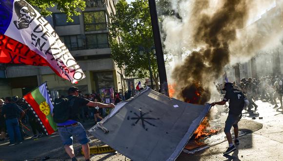 Manifestantes chocan con la policía antidisturbios durante una protesta por el segundo aniversario de meses de levantamiento civil contra la desigualdad social, en Santiago. (Foto: Martin BERNETTI / AFP)